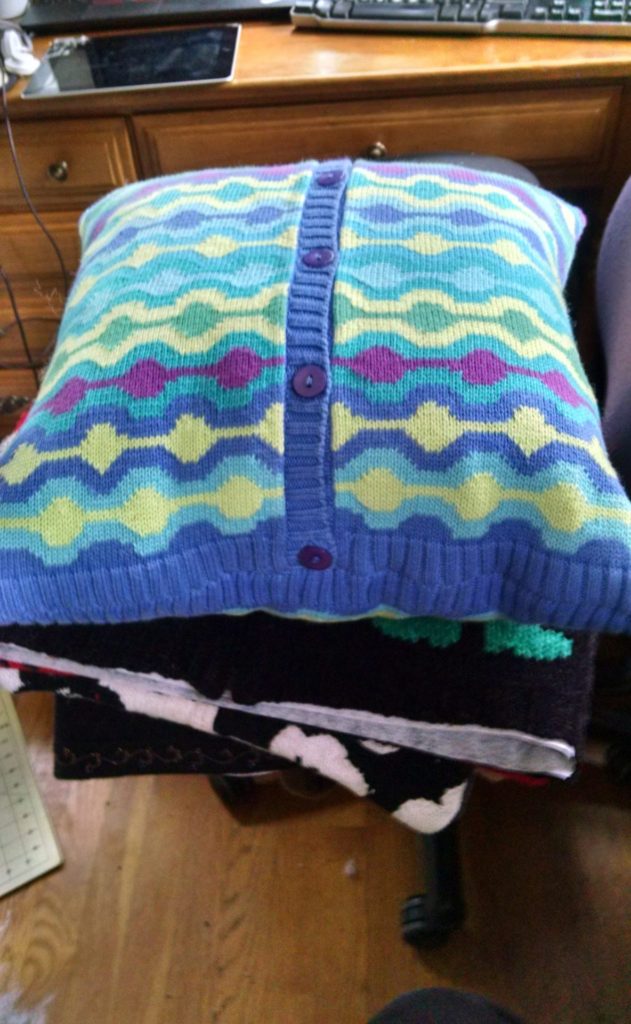 Pillow made out of old sweater, button band showing