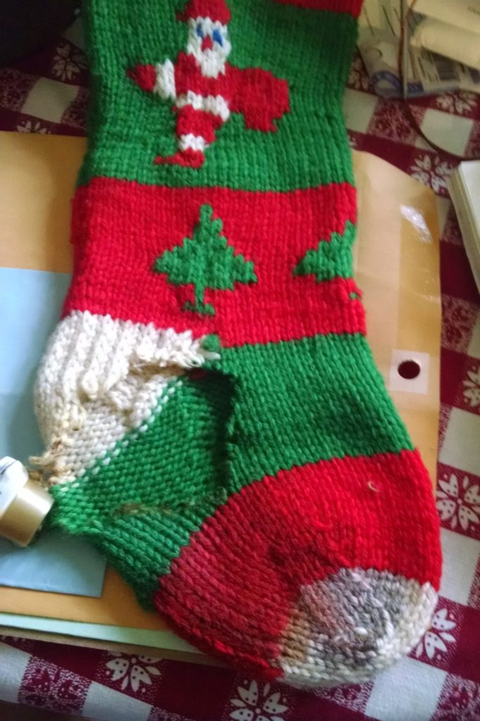 a christmas stocking with a hole burned through it