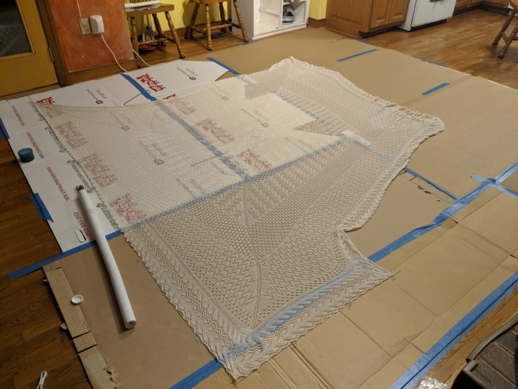chuppah half blocked with lace wires on top of cardboard blocking mat