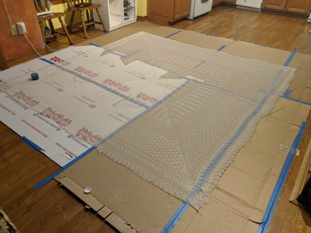 picture of lace chuppah laid out to block on cardboard boxes