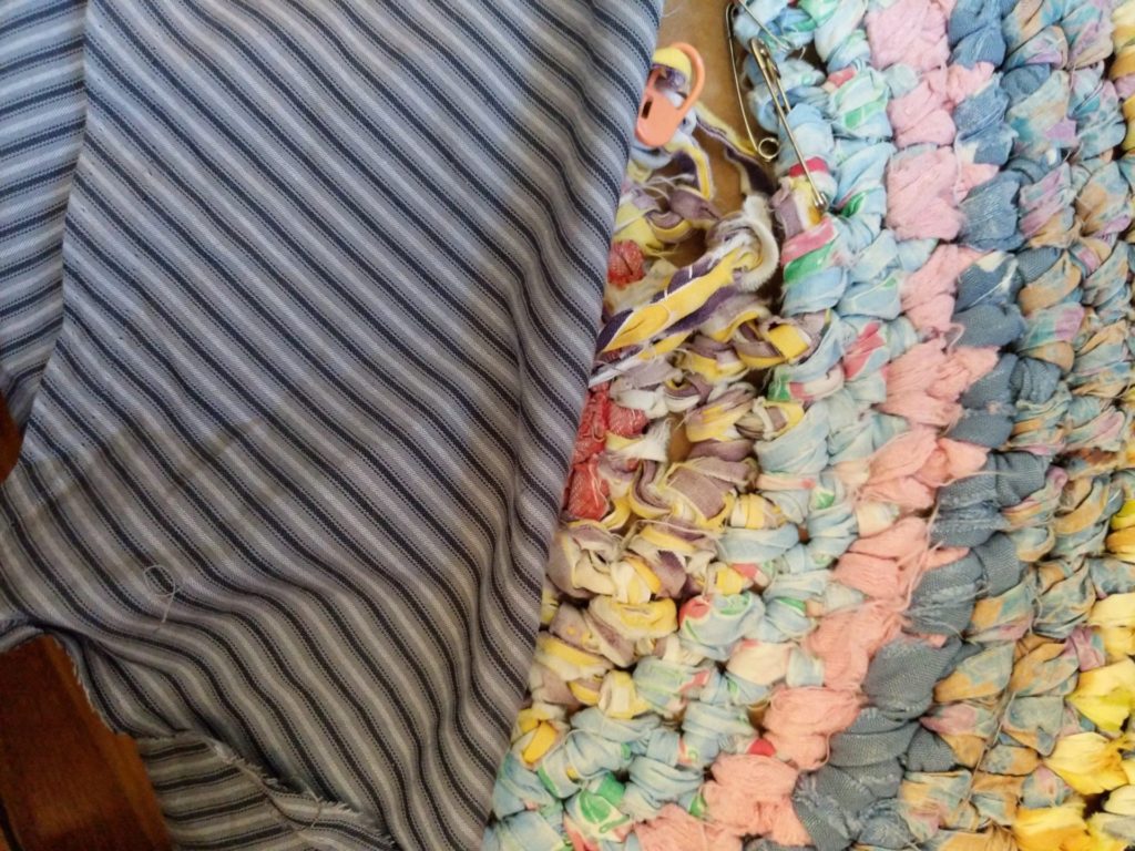 striped men's fabric against damaged rug